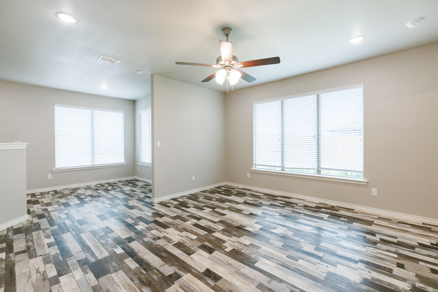 6956 12th Street Lubbock, TX 79416 - Photo 20 of 43 a view of an empty room and window a ceiling fan and wooden floor