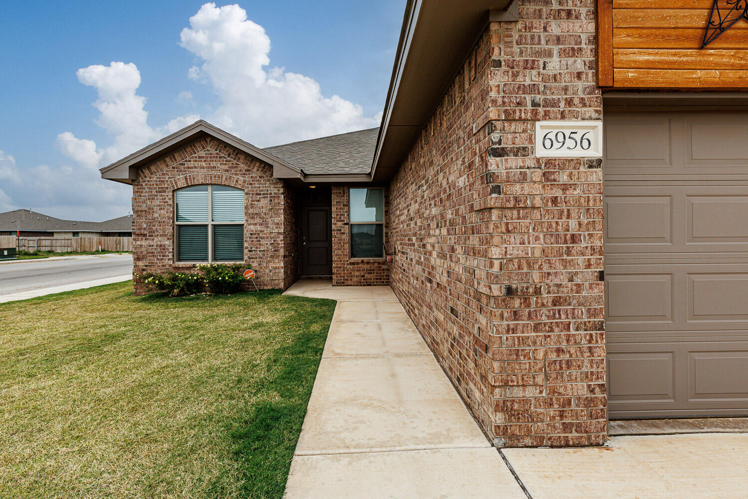 6956 12th Street Lubbock, TX 79416 - Photo 2 of 43 a front view of a house with garden
