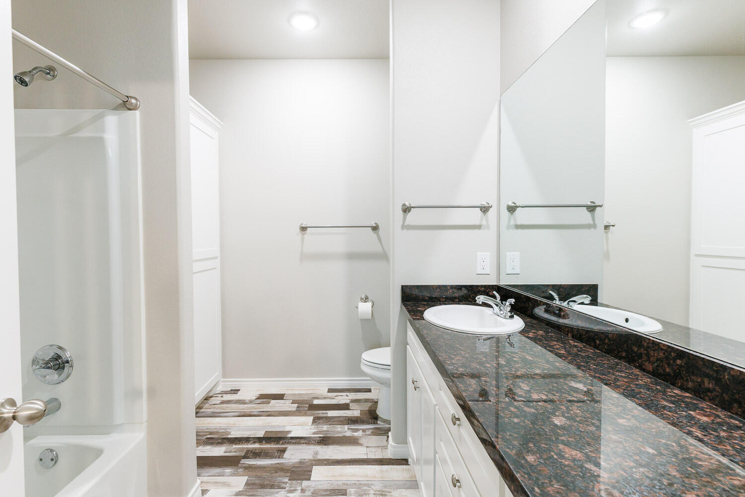 6956 12th Street Lubbock, TX 79416 - Photo 26 of 43 a bathroom with a granite countertop sink and a bathtub