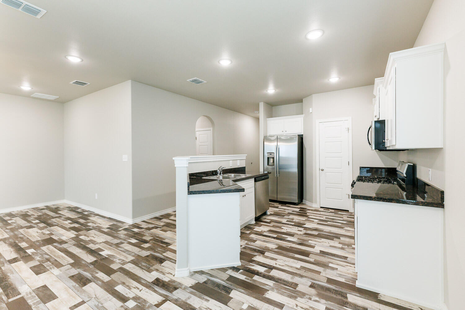 6956 12th Street Lubbock, TX 79416 - Photo 7 of 43 a kitchen with a refrigerator and a stove top oven