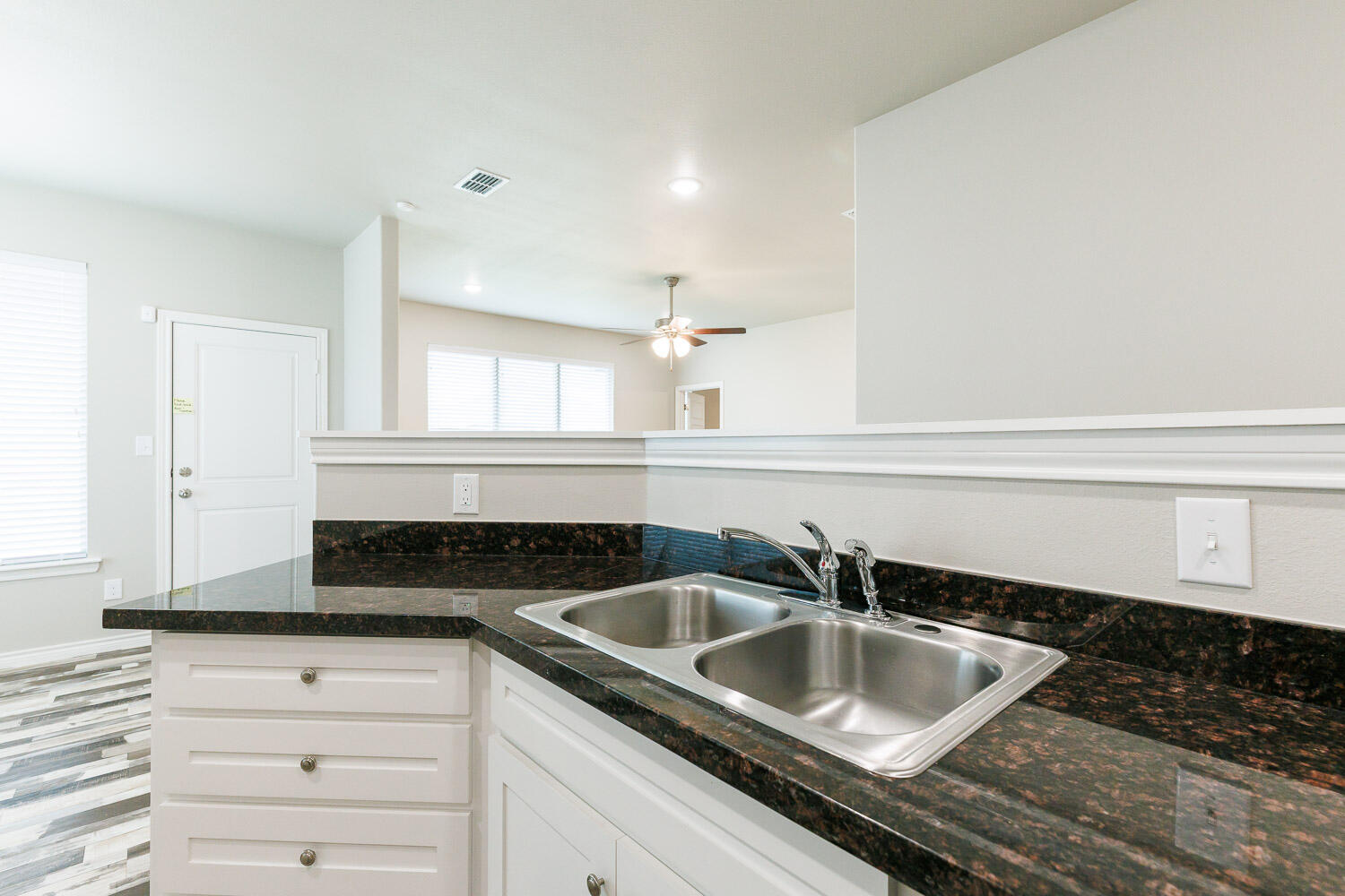 6956 12th Street Lubbock, TX 79416 - Photo 10 of 43 a kitchen with granite countertop a sink and cabinets