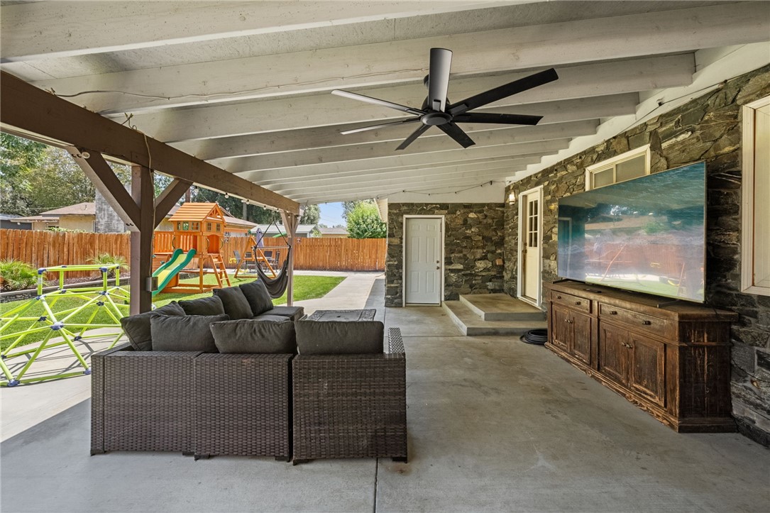 4869 Serrano Place Riverside, CA 92504 - Photo 34 of 40 Spacious covered outdoor living area with seating, ceiling fan, and seamless access to the backyard.