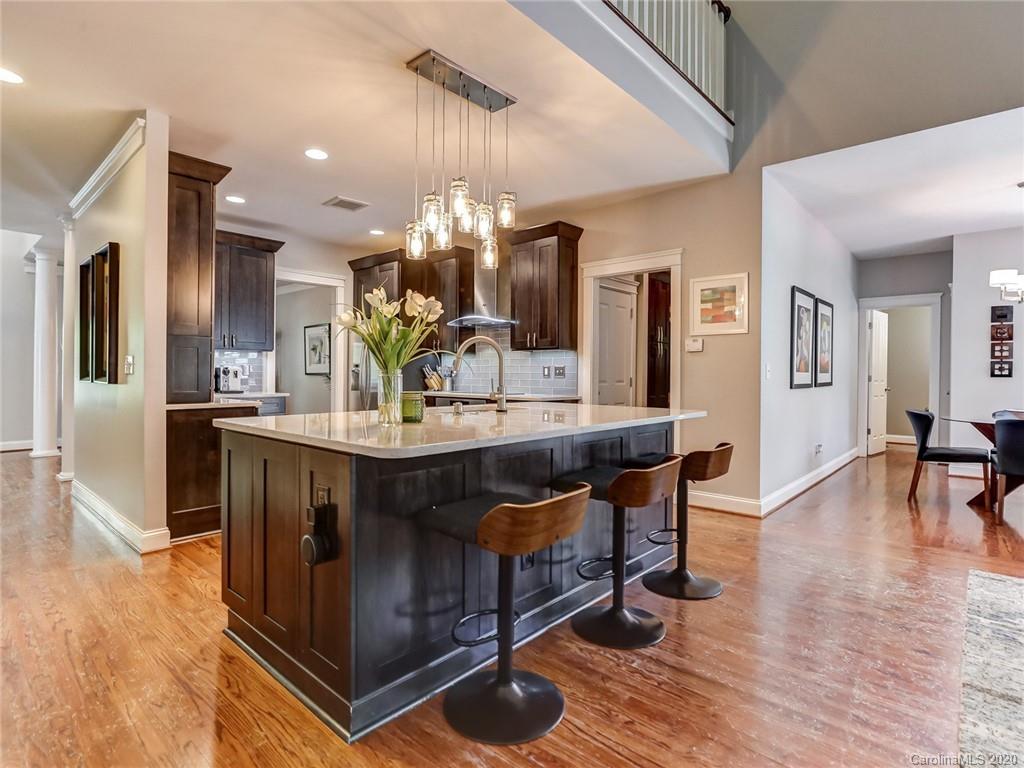 3384 Richard's Crossing Fort Mill, SC 29708 - Photo 14 of 48 a kitchen with stainless steel appliances granite countertop a kitchen island a stove a refrigerator a sink a dining table and chairs with wooden floor