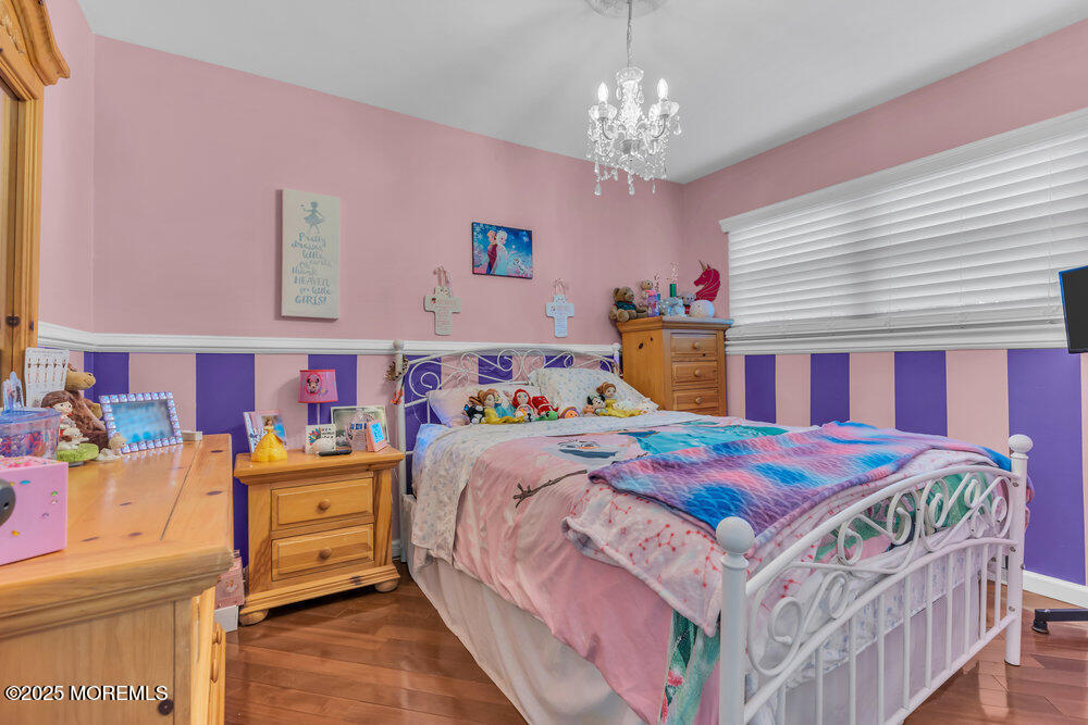 6 Coral Drive Hazlet, NJ 07730 - Photo 16 of 23 a bedroom with a bed a chandelier and dresser