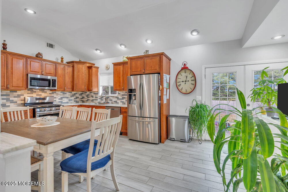 6 Coral Drive Hazlet, NJ 07730 - Photo 4 of 23 a kitchen with stainless steel appliances granite countertop a refrigerator a stove a sink a oven with a dining table and chairs