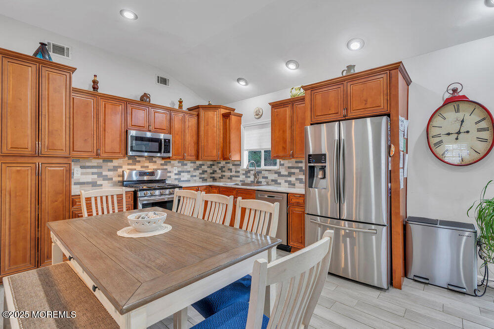 6 Coral Drive Hazlet, NJ 07730 - Photo 5 of 23 a kitchen with stainless steel appliances granite countertop a refrigerator a stove a sink and a dining table with wooden floor