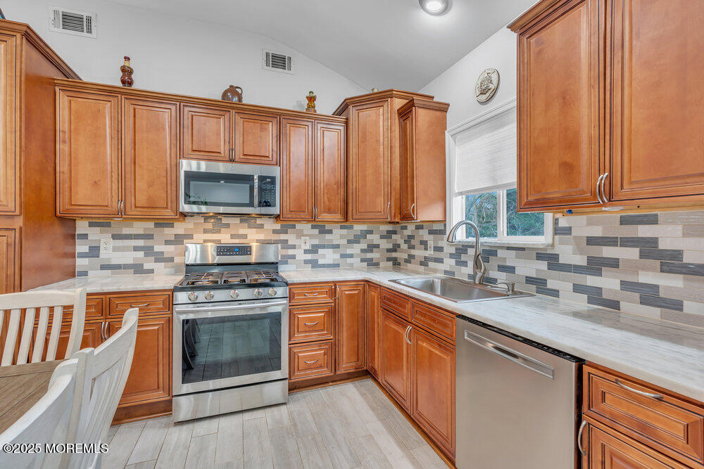 6 Coral Drive Hazlet, NJ 07730 - Photo 6 of 23 a kitchen with stainless steel appliances granite countertop a sink stove and microwave