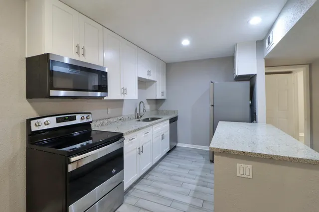 a kitchen with a sink stove and microwave