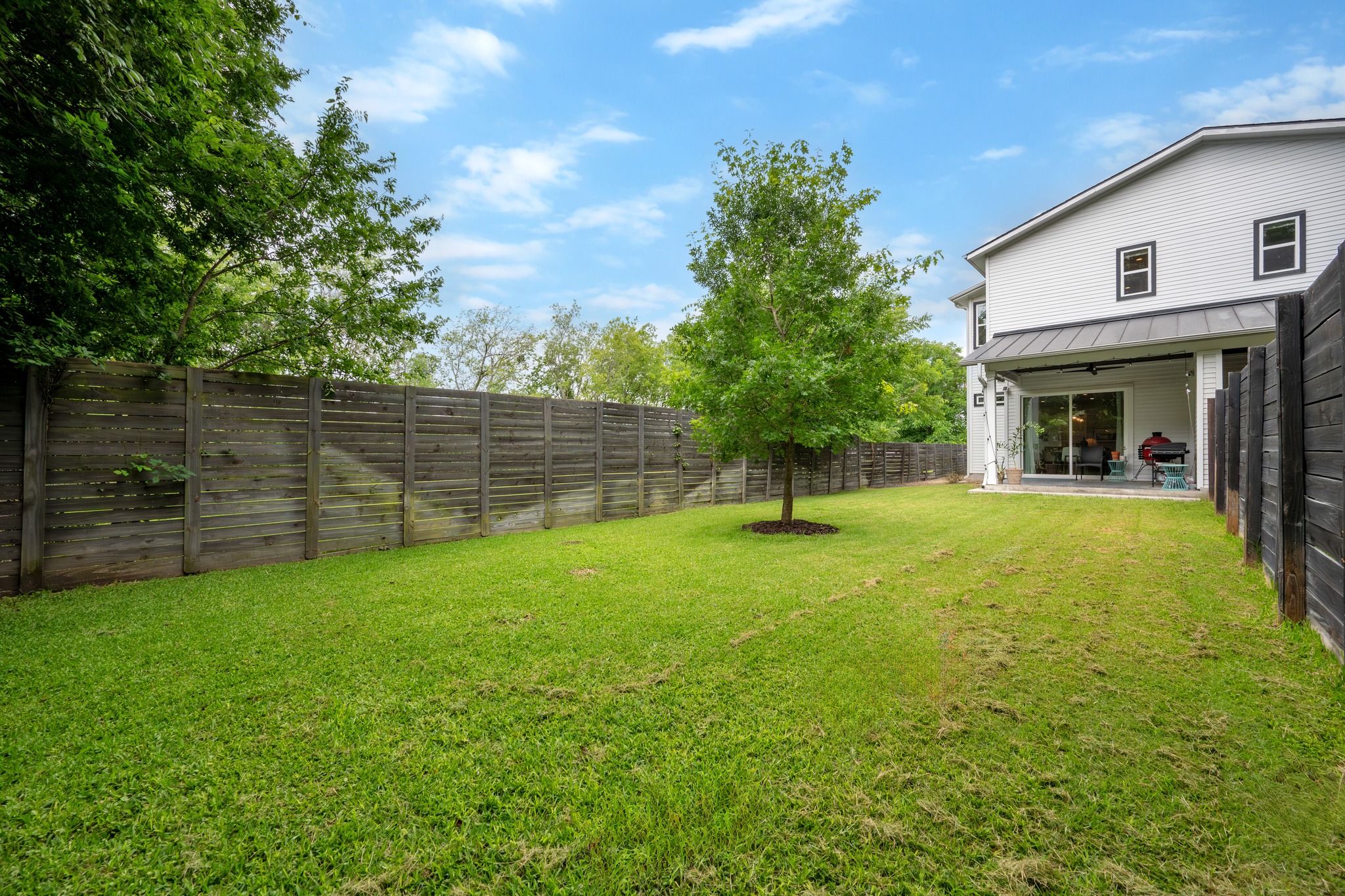 1103 Saucedo Street, Unit 1 Austin, TX 78721 - Photo 39 of 40 A spacious, enclosed backyard offers a verdant lawn and a private patio for outdoor enjoyment.