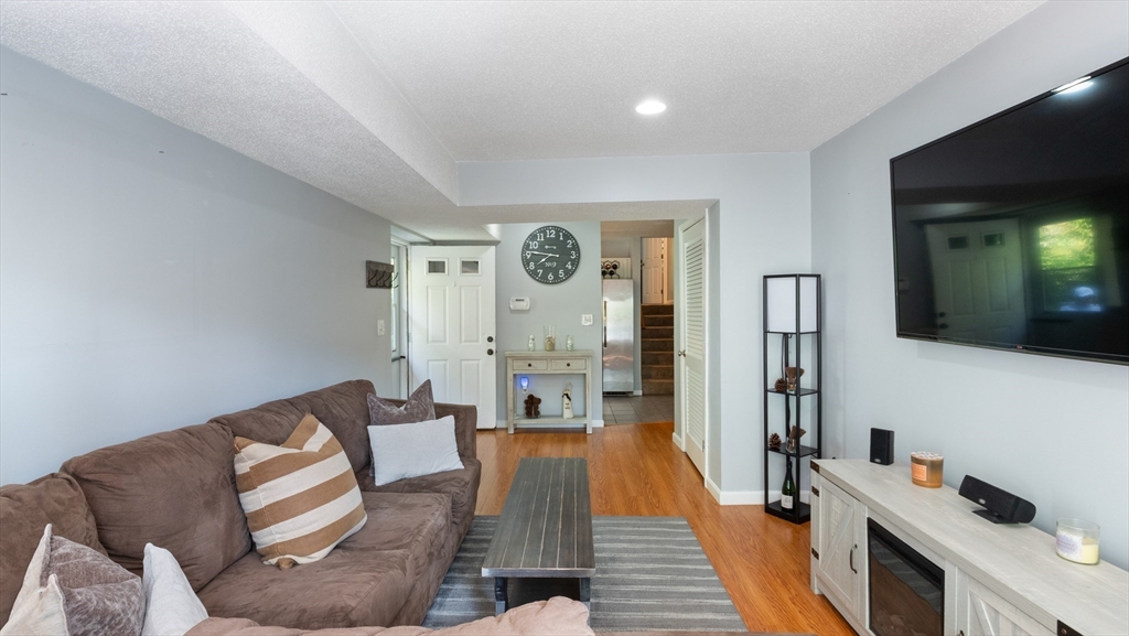 4 Duck Pond Road, Unit 218 Beverly, MA 01915 - Photo 4 of 19 a living room with furniture and wooden floor