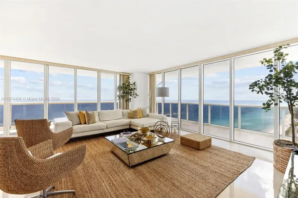 a living room with furniture and a floor to ceiling window