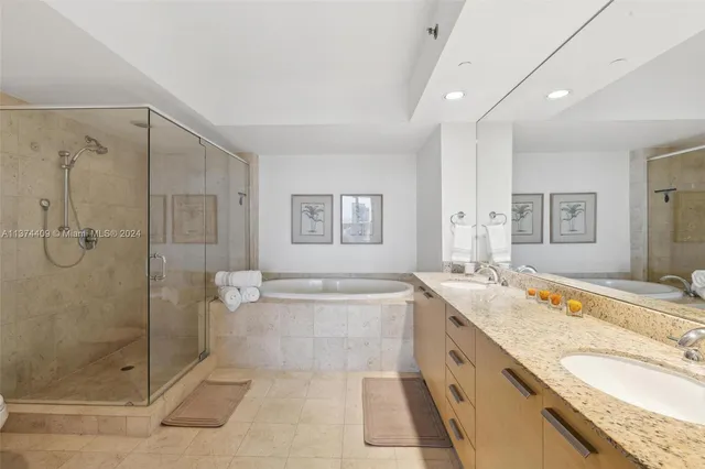 a bathroom with a granite countertop sink mirror and bathtub