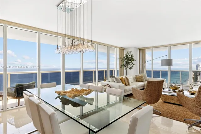 a living room with furniture large windows a rug and white walls