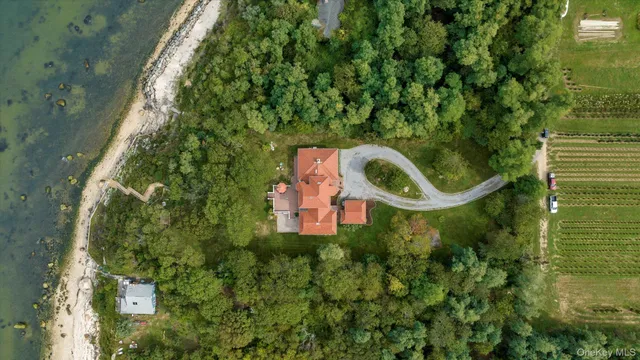 a aerial view of a house with a yard and lake view