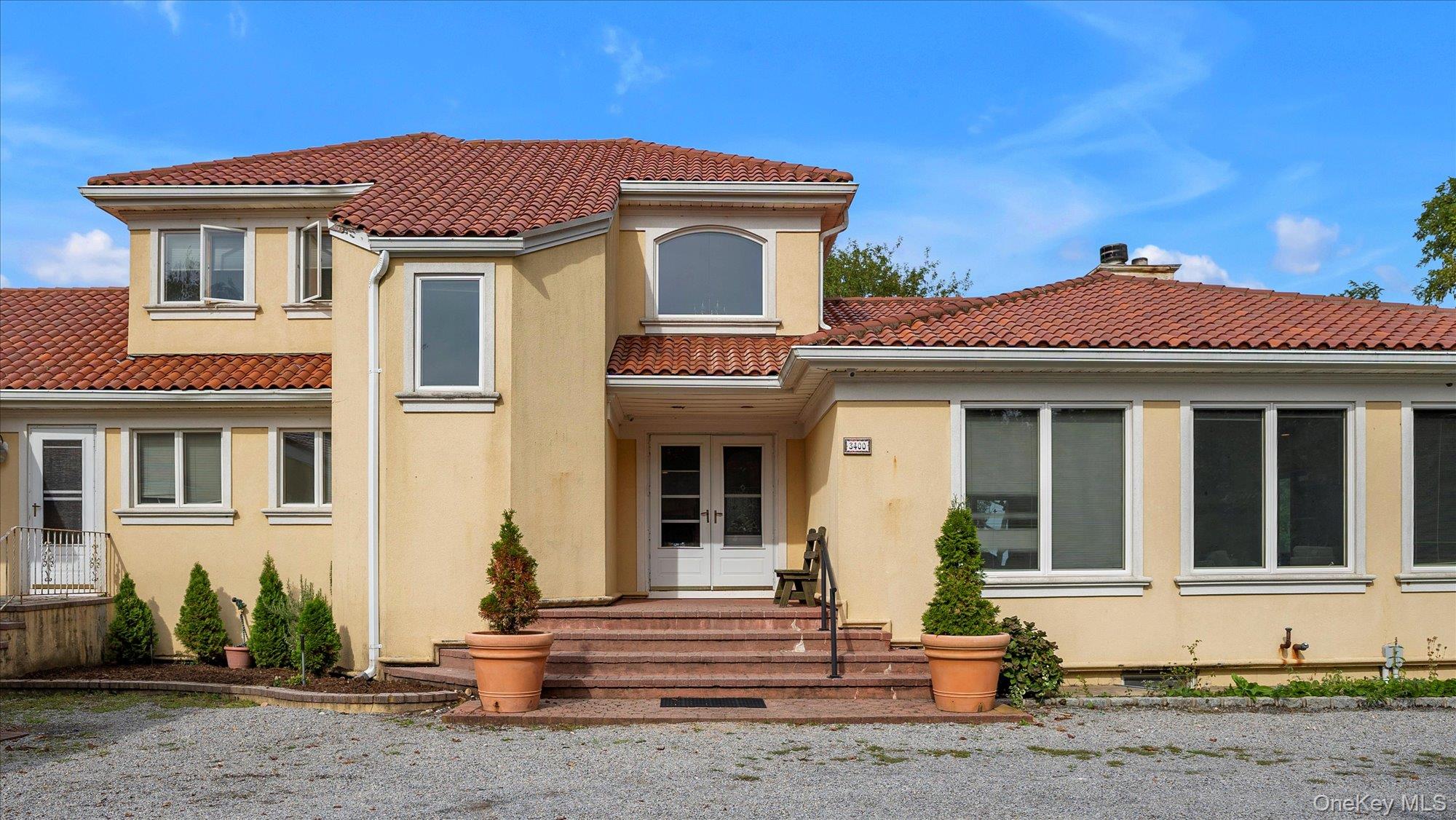 3400 Dignans Road Cutchogue, NY 11935 - Photo 3 of 34 Back of property with stucco siding, a chimney, a tile roof, and french doors