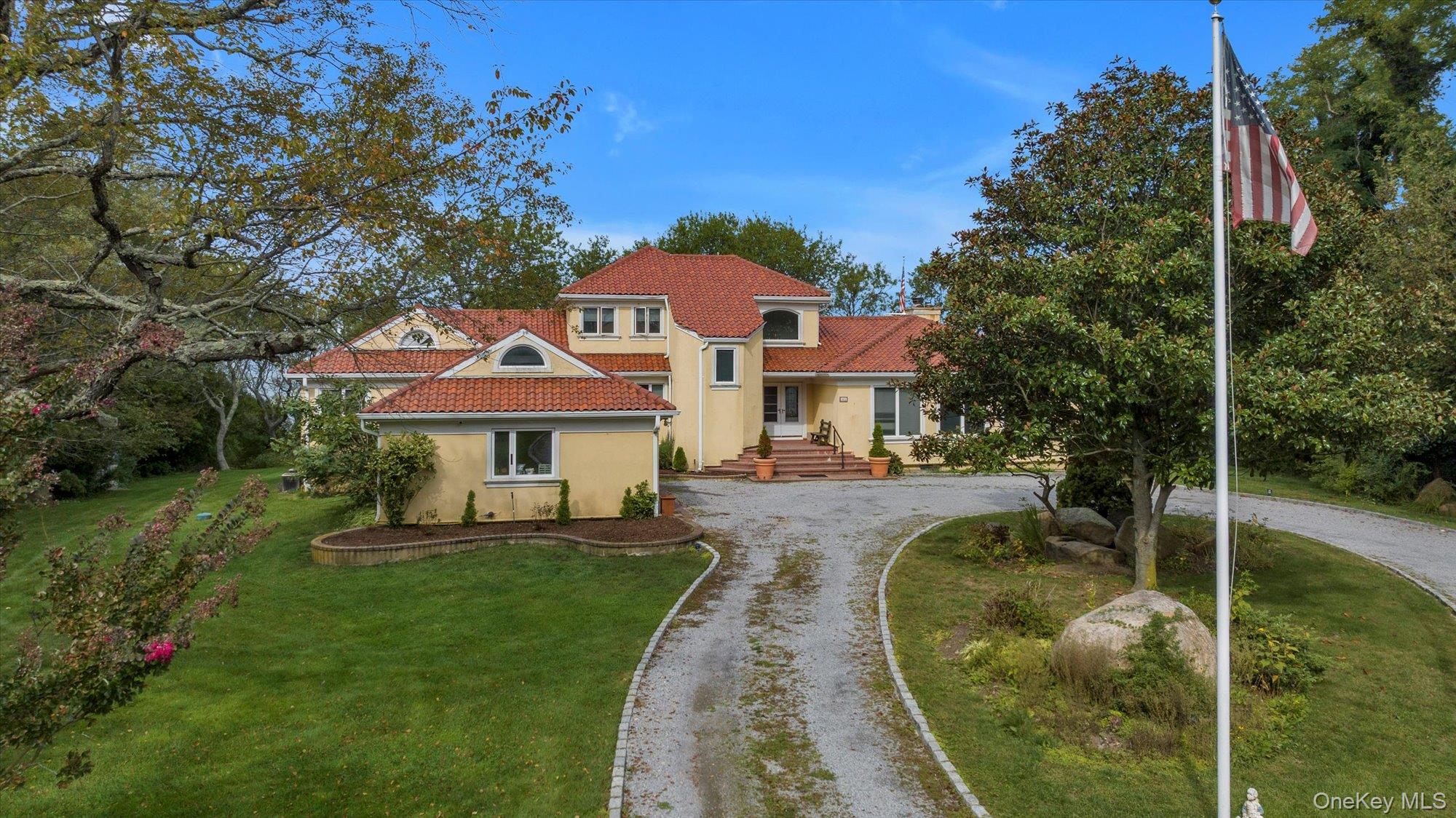 3400 Dignans Road Cutchogue, NY 11935 - Photo 34 of 34 Mediterranean / spanish-style home with stucco siding, a tile roof, a front yard, and driveway