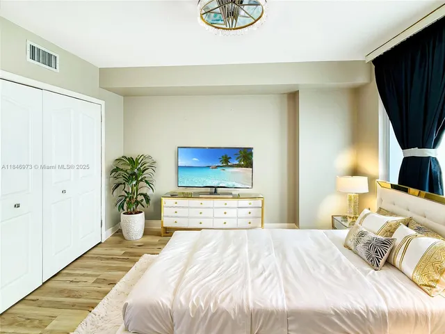 a bedroom with a bed and a flat screen tv