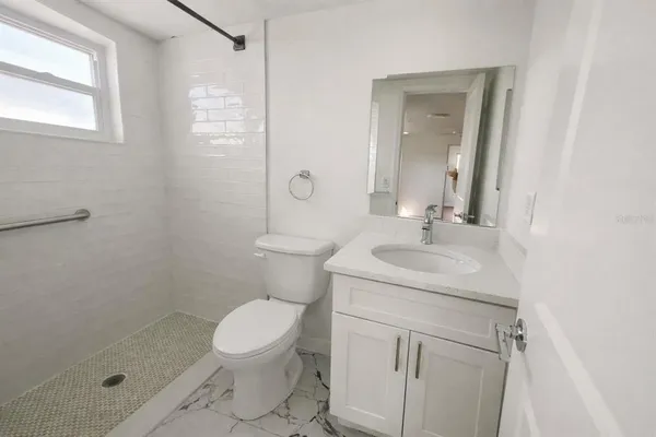 a bathroom with a sink a toilet and shower
