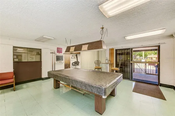 a room with pool table and windows