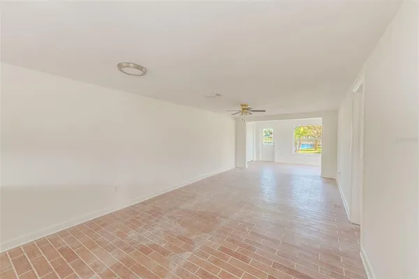 a view of a hallway with wooden floor and a window