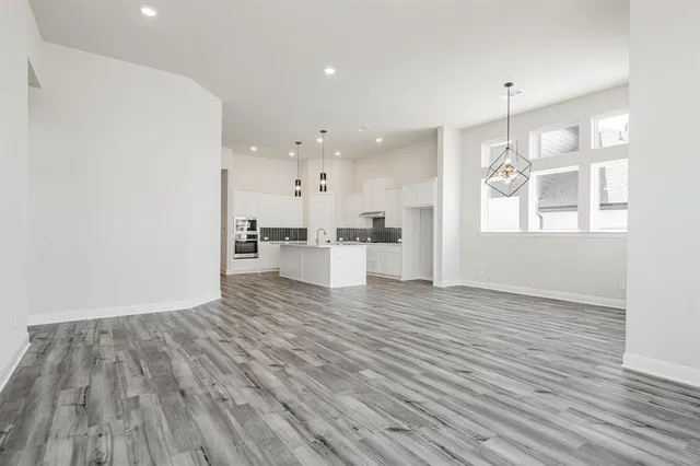 a view of a kitchen with wooden floor and window
