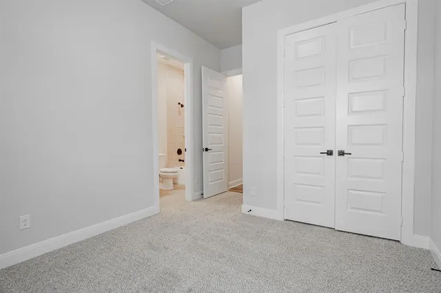 an empty room with white cabinet and door
