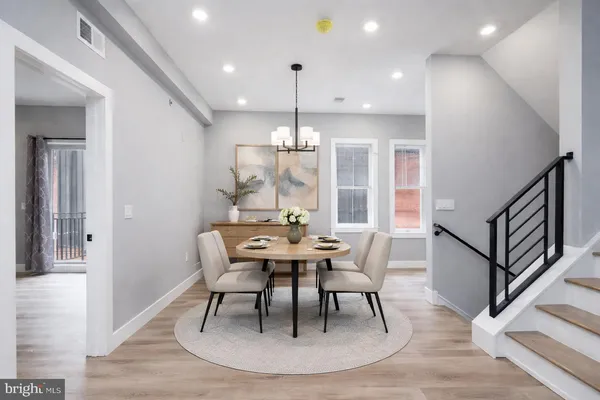 a dining room with furniture a chandelier and wooden floor