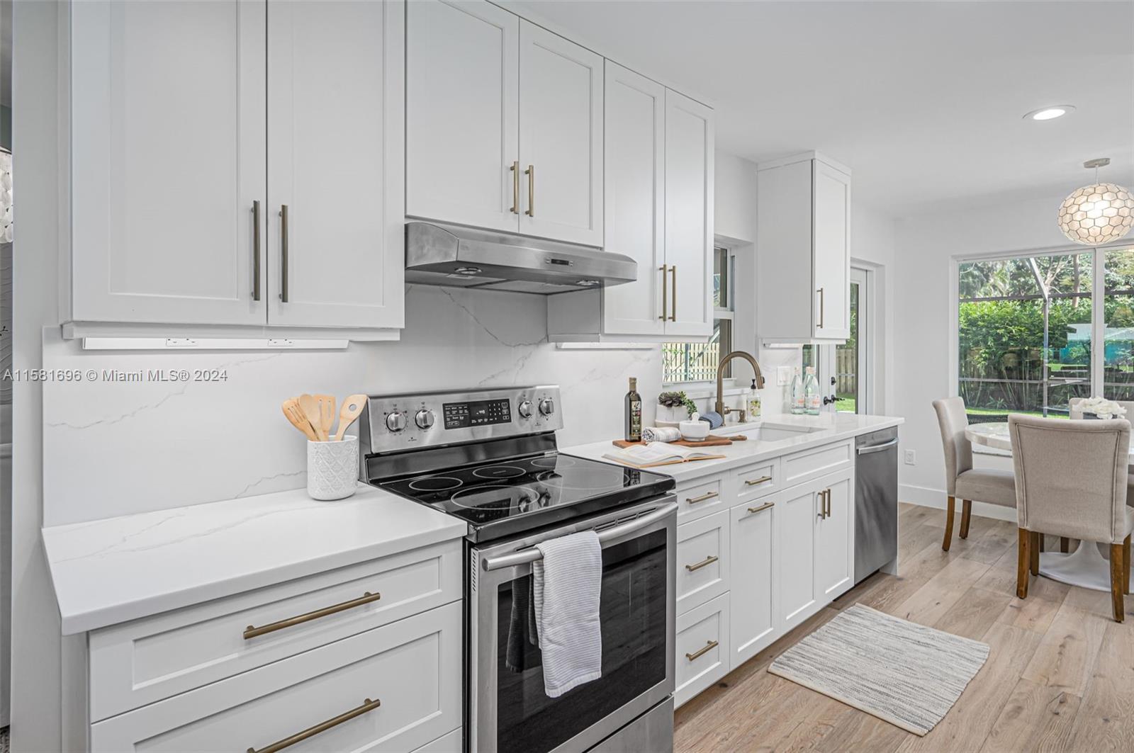138 Buttonwood Way Tequesta, FL 33469 - Photo 11 of 27 a kitchen with white cabinets and white appliances
