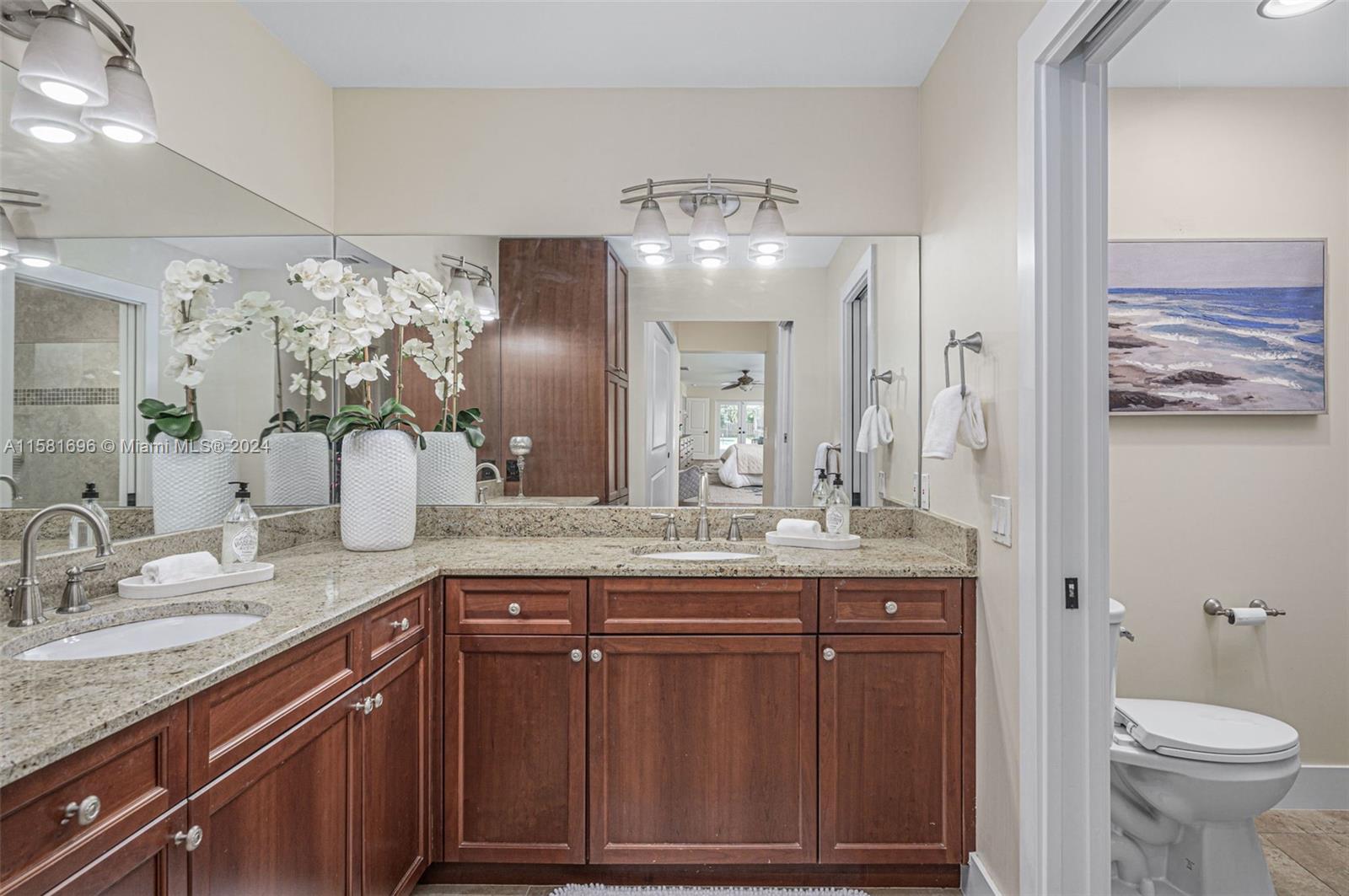 138 Buttonwood Way Tequesta, FL 33469 - Photo 20 of 27 a bathroom with a granite countertop sink a toilet a large mirror and shower