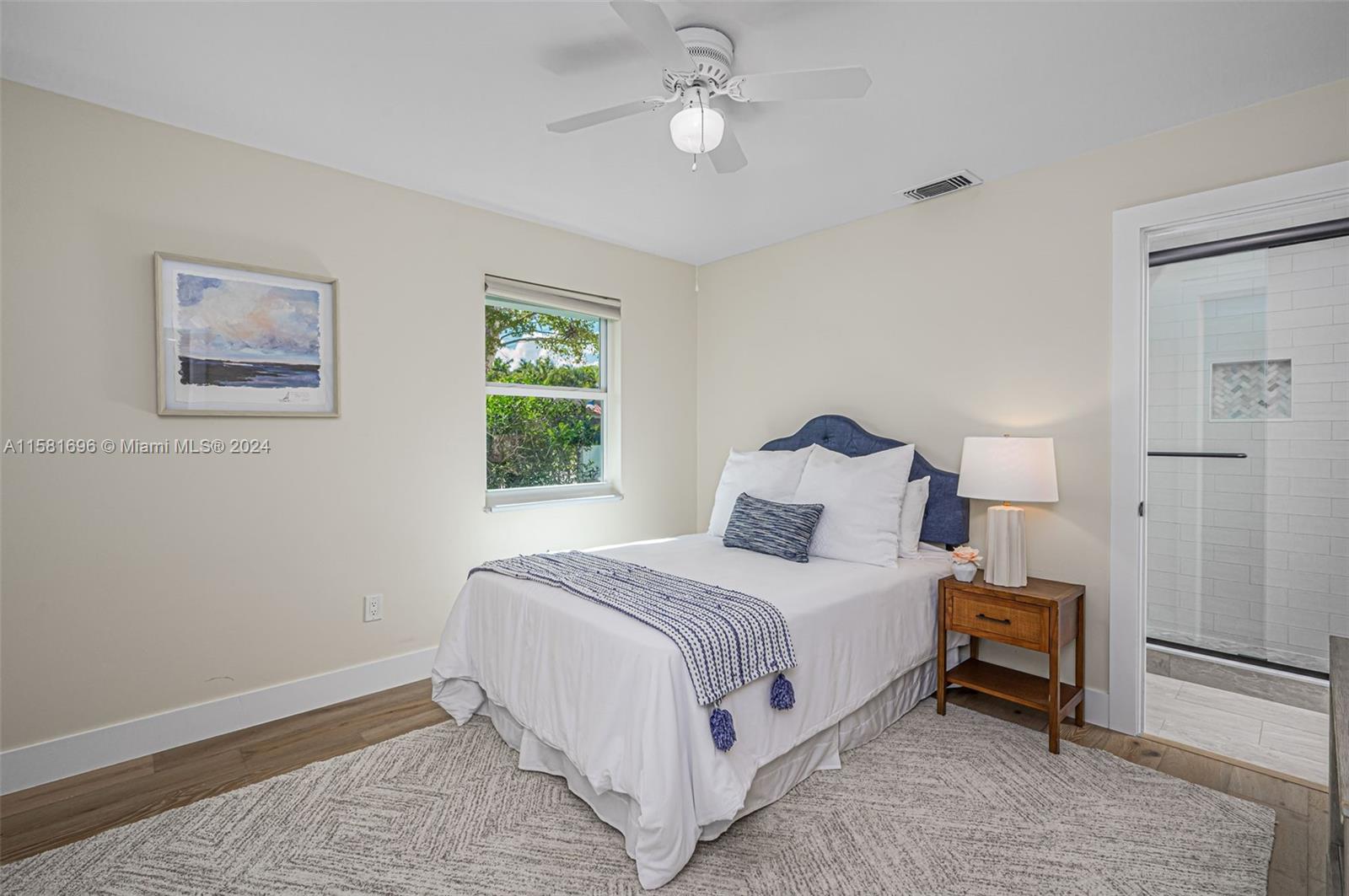 138 Buttonwood Way Tequesta, FL 33469 - Photo 21 of 27 a large bed sitting in a bedroom next to a window and a chandelier