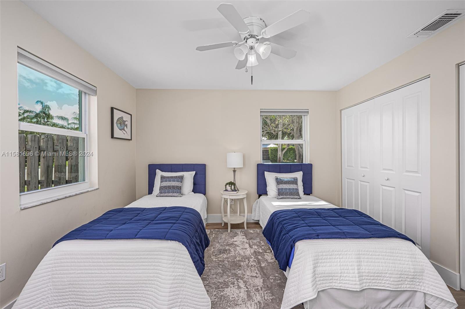138 Buttonwood Way Tequesta, FL 33469 - Photo 23 of 27 a bedroom with two beds and a chandelier