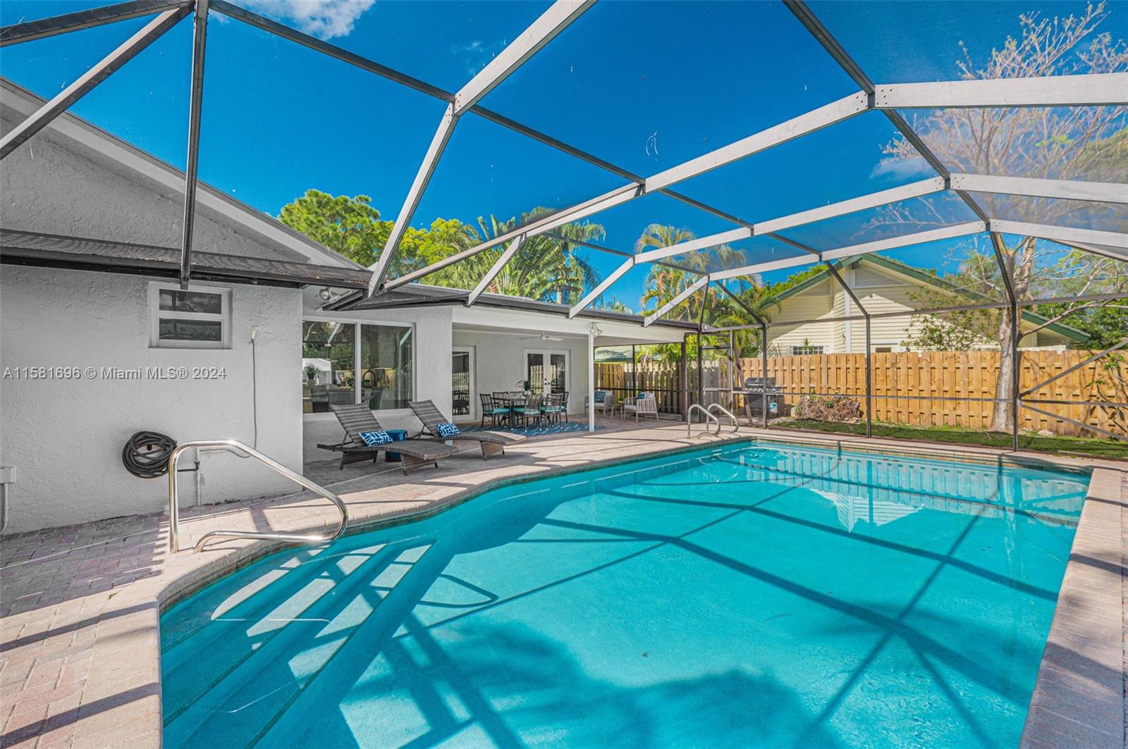 138 Buttonwood Way Tequesta, FL 33469 - Photo 26 of 27 a view of a backyard with table and chairs under an umbrella
