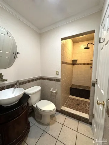 a bathroom with a granite countertop sink a toilet and shower