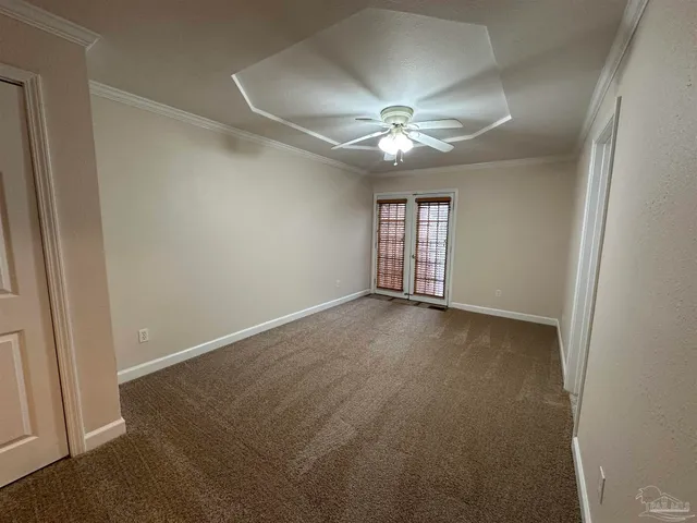 an empty room with a fan & a window