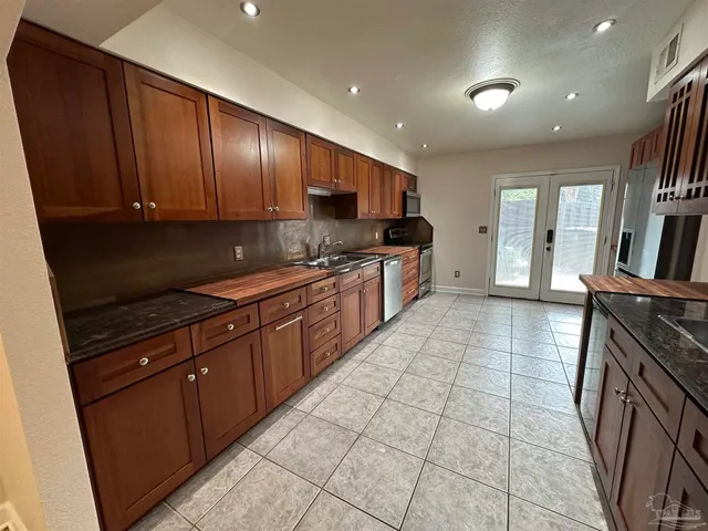 a kitchen with stainless steel appliances granite countertop wooden cabinets a sink and dishwasher