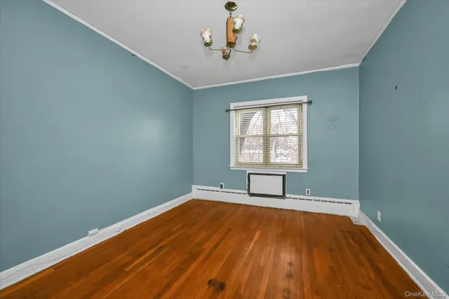 a view of a room with wooden floor and exposed radiator