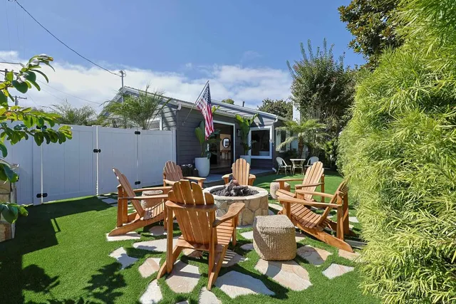 a view of a patio with table and chairs potted plants and large tree