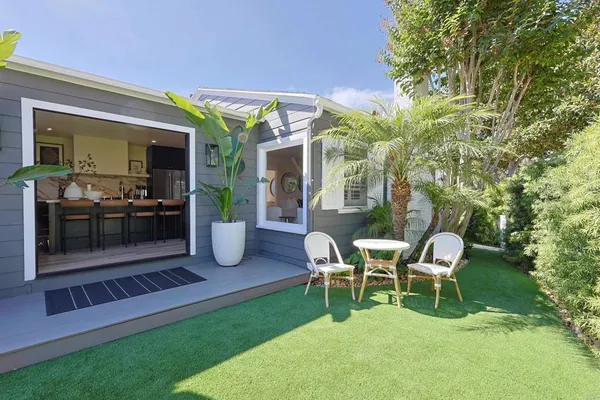 a view of a chair and table in backyard of the house