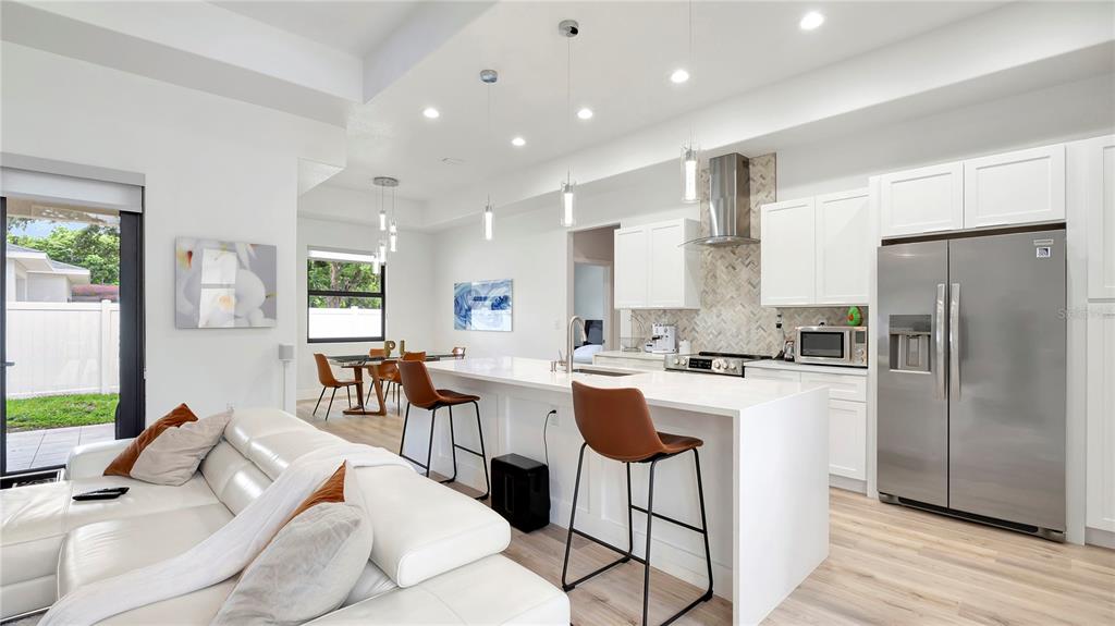 306 East Clay Avenue Brandon, FL 33510 - Photo 3 of 26 a kitchen with stainless steel appliances kitchen island granite countertop a refrigerator a stove a sink dishwasher and white cabinets with wooden floor