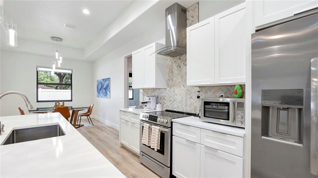 306 East Clay Avenue Brandon, FL 33510 - Photo 6 of 26 a kitchen with stainless steel appliances a stove a sink a microwave and cabinets