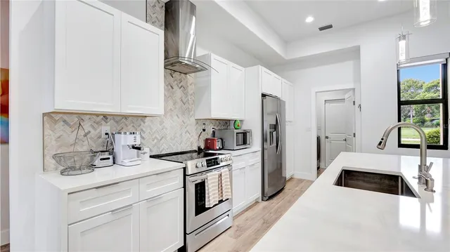 a kitchen with stainless steel appliances a stove a sink and a refrigerator