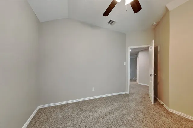 an empty room with closet and wall fan