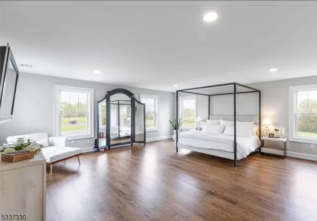 a spacious bedroom with a bed and a flat screen tv