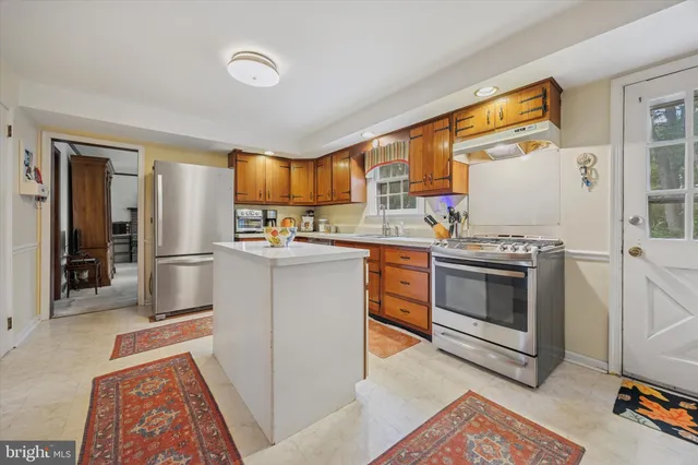 a kitchen with stainless steel appliances granite countertop a stove a sink and a refrigerator