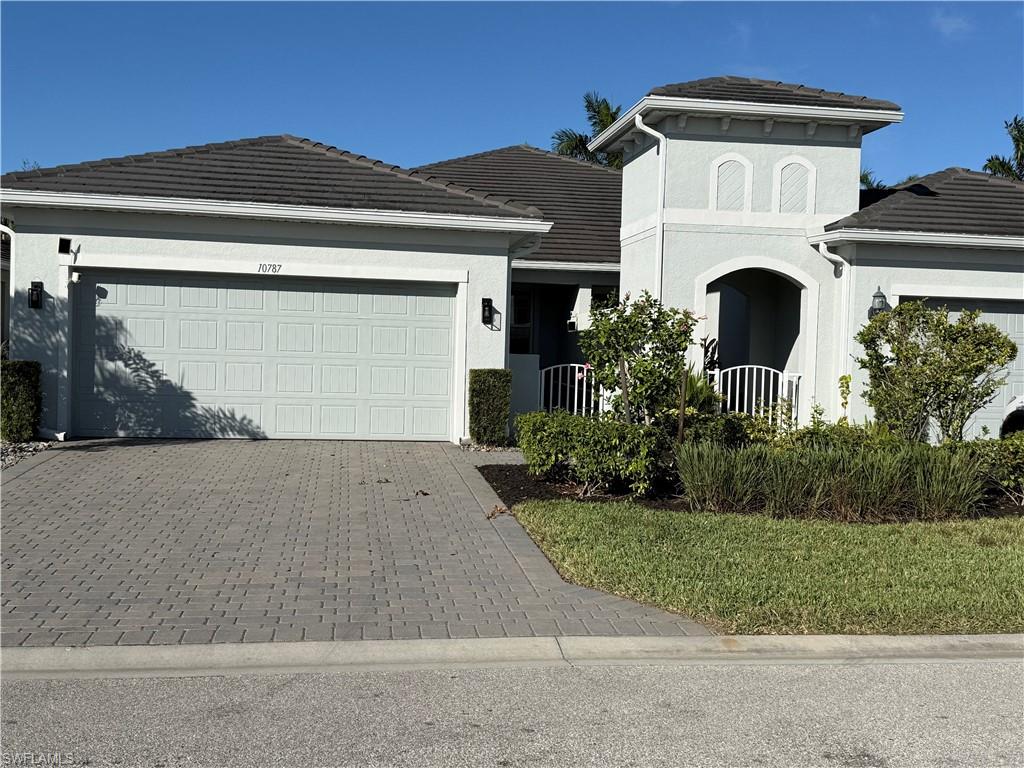 10787 Manatee Key Lane Estero, FL 33928 - Photo 3 of 31 a front view of a house with a yard and garage