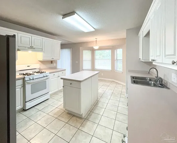 a kitchen with a sink stove and cabinets
