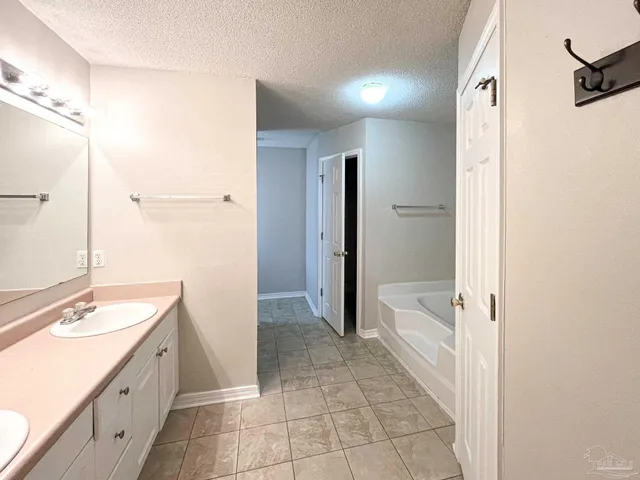 a bathroom with a granite countertop sink a mirror and a bathtub