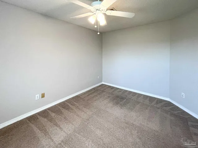 an empty room with a fan and a ceiling fan