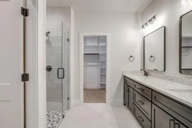 a spacious bathroom with a granite countertop sink mirror and shower