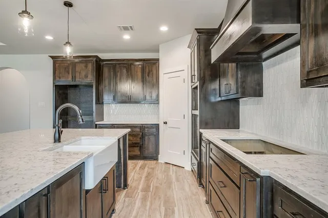 a kitchen with granite countertop a sink stainless steel appliances and cabinets